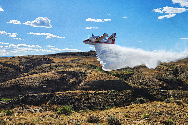 Fire A firefighting plane drops retardants on the ground below.