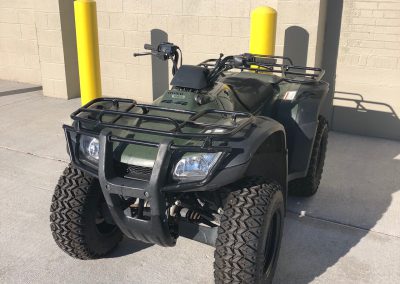 Olive-green Honda utility ATV with cargo racks is shown as an example of Federal Excess Personal Property currently in service
